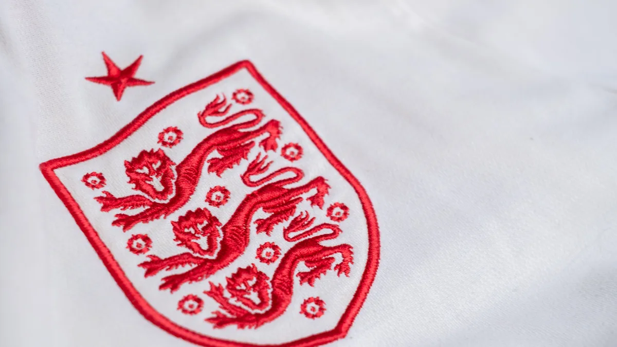 Detaillierte Betrachtung des Emblems der englischen Fußballnationalmannschaft auf einem Trikot.