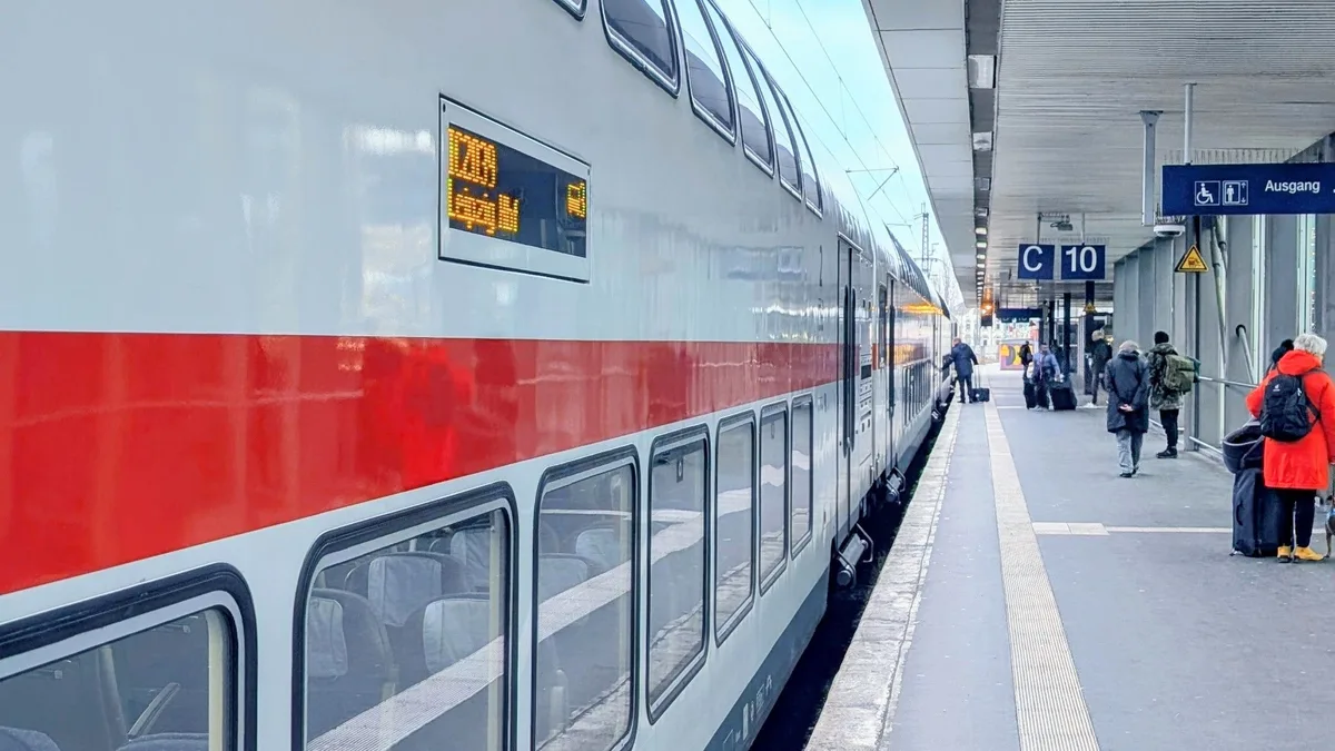 Doppelstockzug im Bahnhof Hannover mit Reisenden auf dem Bahnsteig.