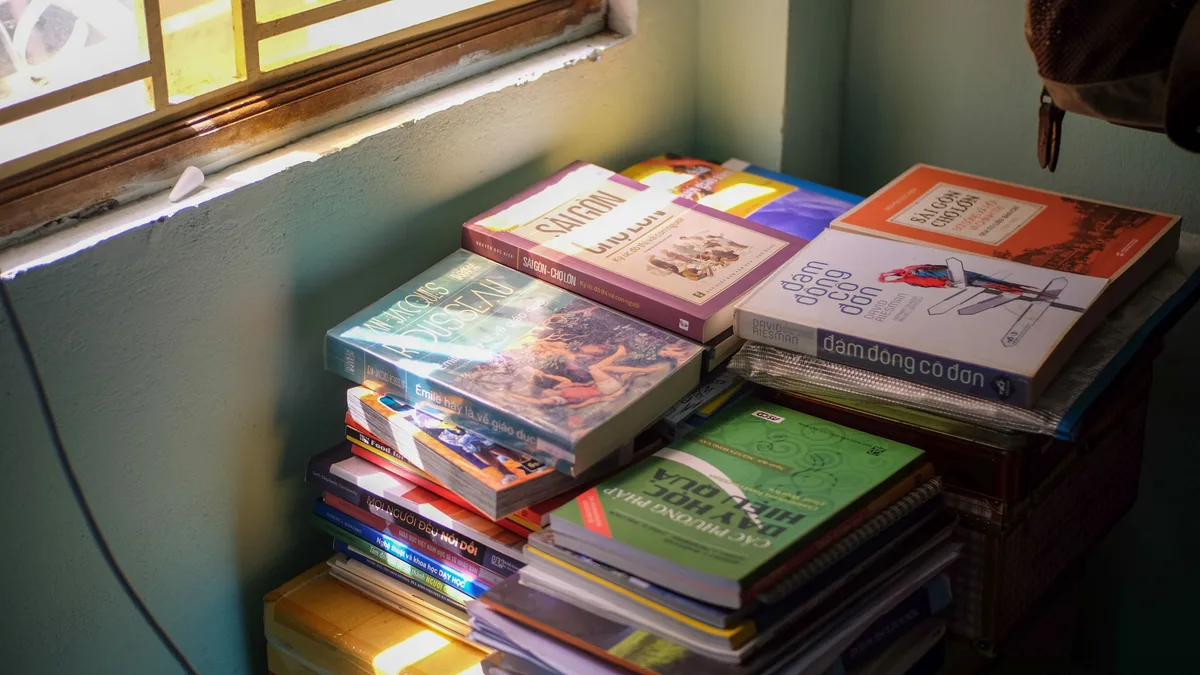 Ein gemütlicher Stapel von Büchern, erleuchtet vom Morgenlicht, das friedliche Vibes in Hue, Vietnam einfängt.
