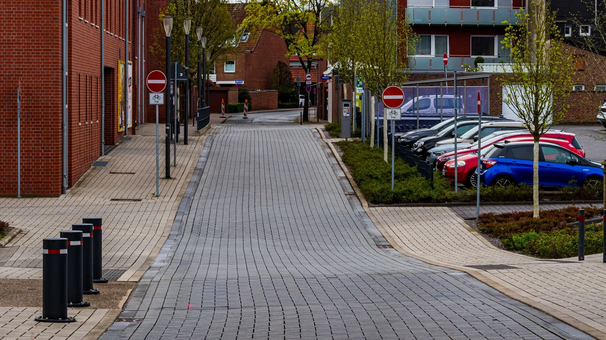 Ruhige Straßenansicht in Coesfeld, Deutschland, mit moderner Architektur und geparkten Autos.