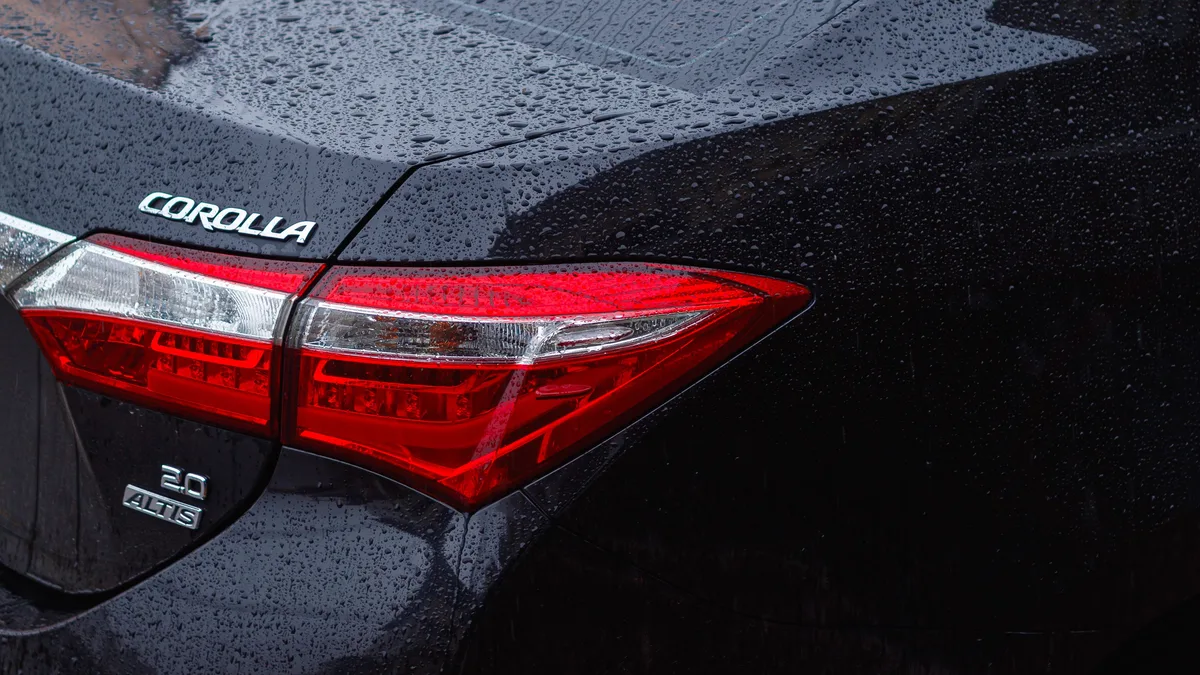 Detaillierte Rückansicht eines Toyota Corolla im Regen, die Wassertropfen auf der Fahrzeugoberfläche zeigt.