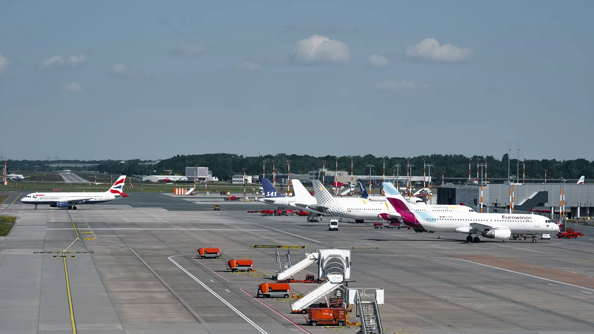 Flugzeuge auf der Landebahn am Flughafen Hamburg an einem klaren Tag, die lebhaften Luftverkehr zeigen.