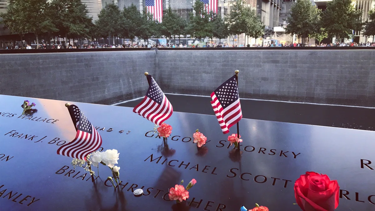 Eine berührende Hommage im 9/11-Memorial in NYC mit Flaggen und Blumen zu Ehren der Opfer.