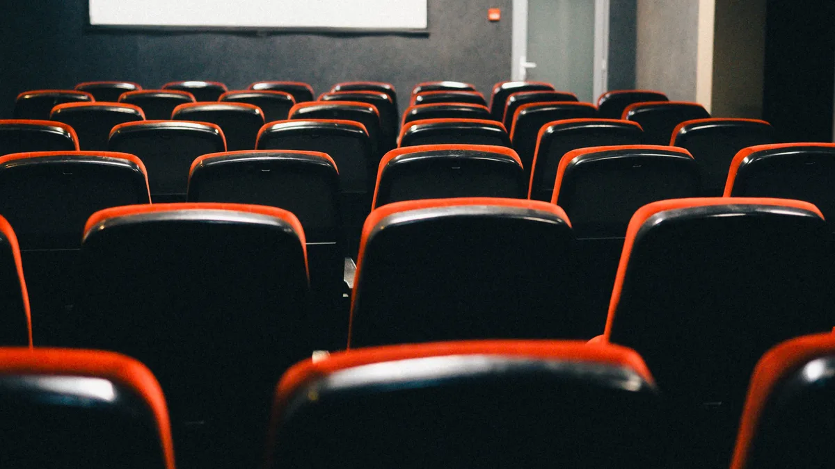 Eine filmreife Ansicht eines leeren Theaters mit rot umrandeten Sitzen, perfekt für Filmthemen.