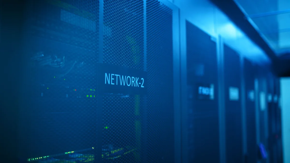 Ein moderner Serverraum mit Netzwerkausrüstung und blauer Beleuchtung. Ideal für Technologiethemen.