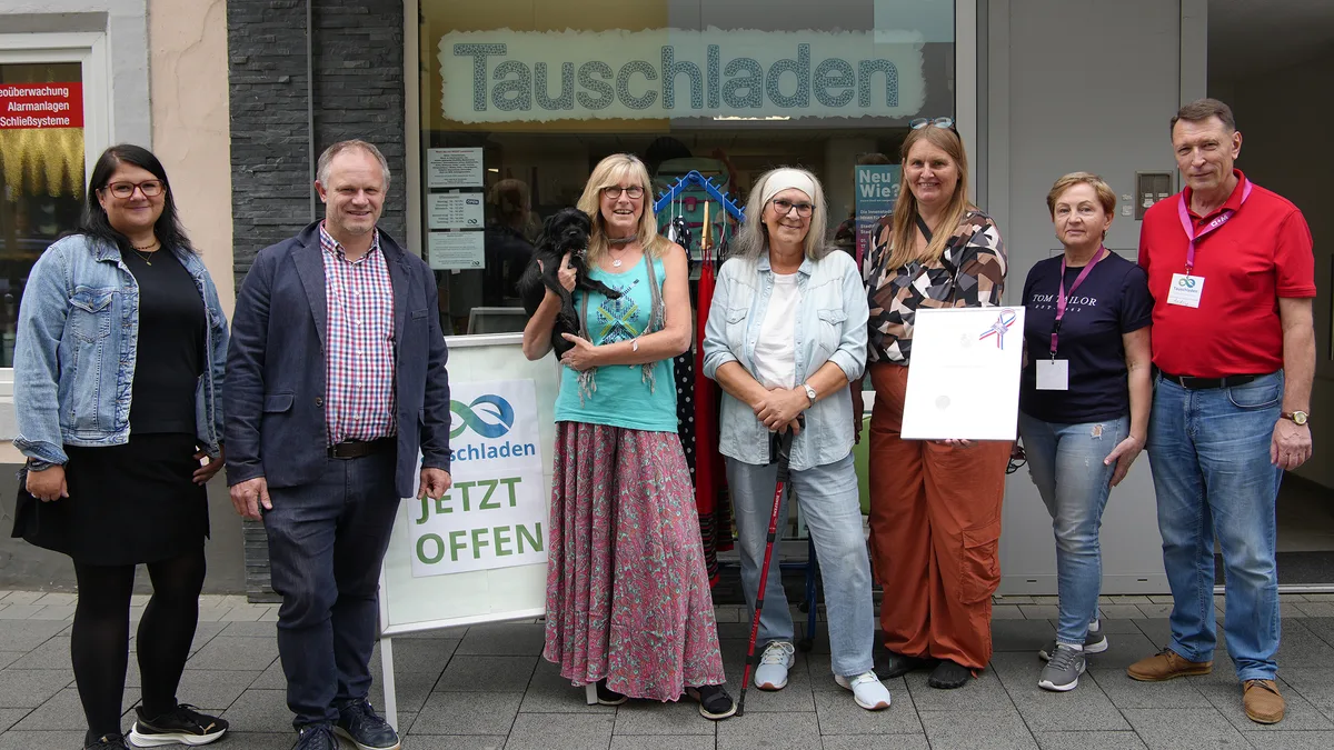 Oberbürgermeister Jan Einig und City-Managerin Michaela Ullrich mit Ehrenamtlichen des Tauschladens vor dem Laden in der Engerser Straße