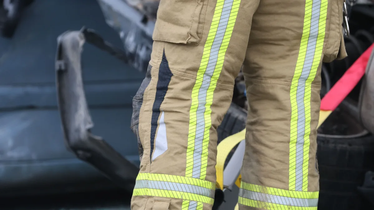 Feuerwehrmann in reflektierender Ausrüstung an der Unfallstelle in der Stadt, mit Fokus auf Sicherheit.