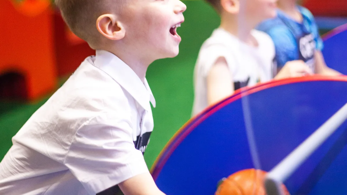 Kinder haben Spaß beim Spielen eines Basketball-Automatenspiels drinnen in Moskau.