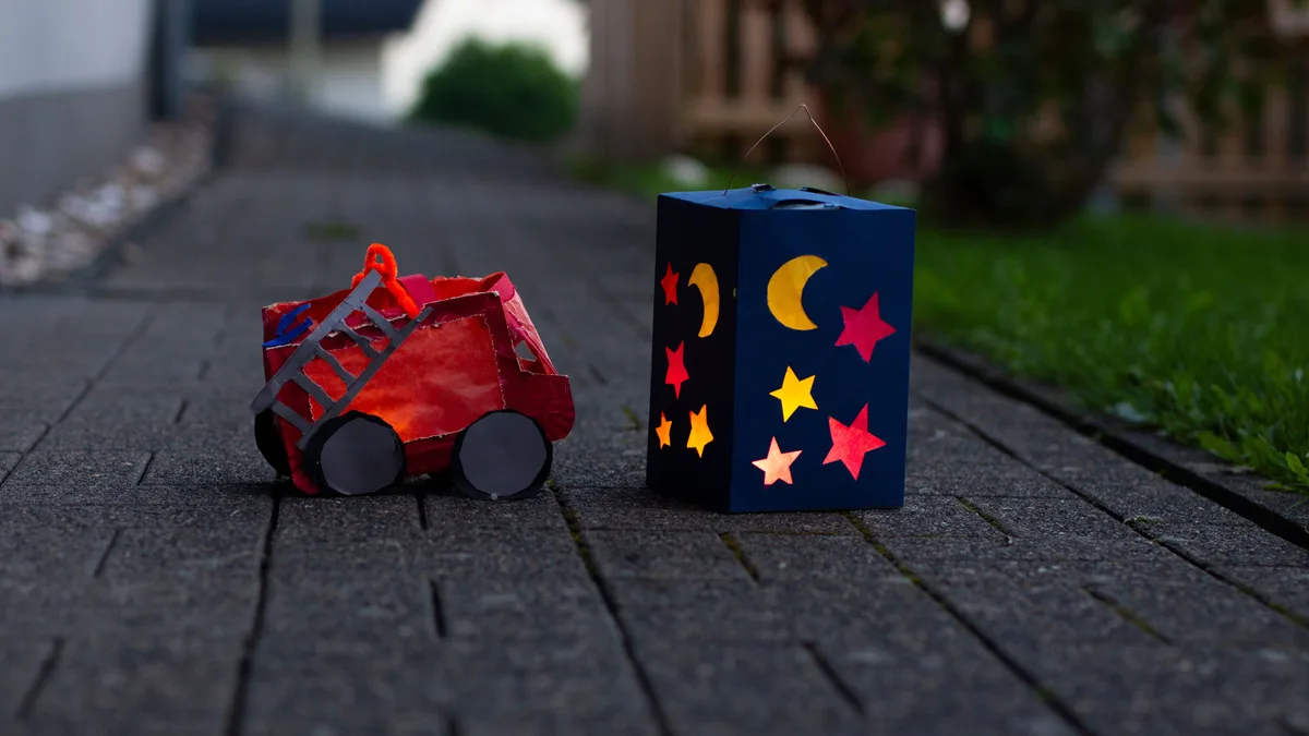 Bunte Papierlaternen erhellen einen Herbstabendweg und wecken Assoziationen von Wärme und Tradition.