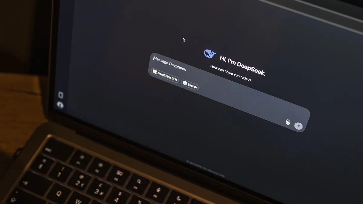 Ein Laptop auf einem Holztisch zeigt eine KI-Chat-Schnittstelle mit dem DeepSeek-Chatbot in Aktion.