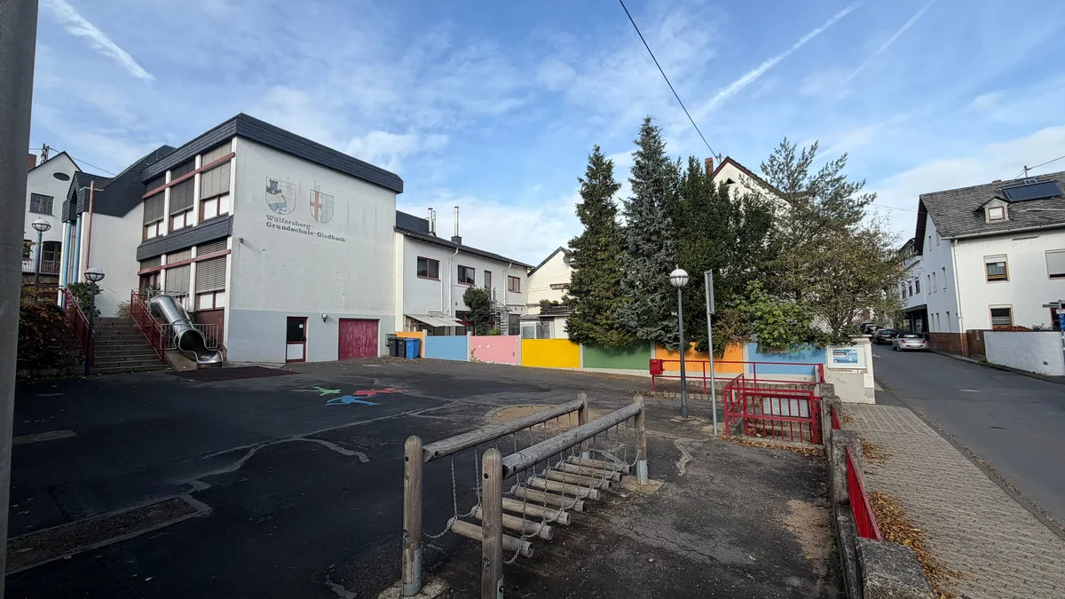 Farbig gestaltete Mauer in Gladbach, dahinter liegt das Grundstück An der Marienkirche 13, das die Stadt Neuwied neben der Wülfersberg-Grundschule erwerben will