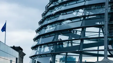 Die Glaskuppel des Reichstags in Berlin, Deutschland, präsentiert moderne Architektur unter bewölktem Himmel.