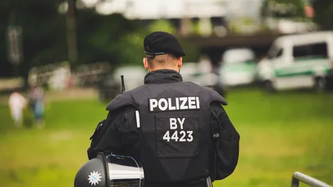Ein Polizeibeamter steht in Uniform im Freien und hebt die Strafverfolgung hervor.