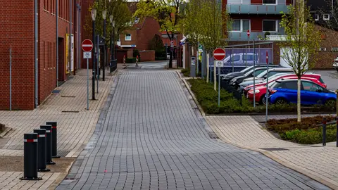 Ruhige Straßenansicht in Coesfeld, Deutschland, mit moderner Architektur und geparkten Autos.