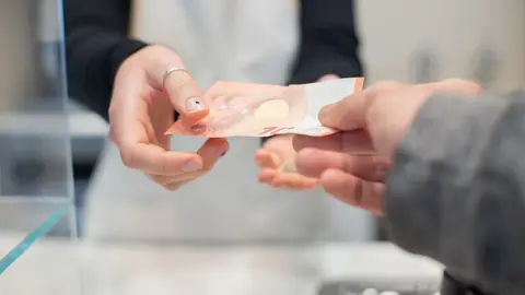 Nähe Interaktion von Händen, die Bargeld in einem Café austauschen. Detail der Geschäftstransaktion.