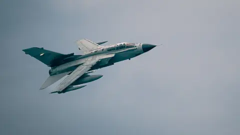 Ein Panavia Tornado-Kampfflugzeug, das durch einen bewölkten Himmel fliegt und Kraft und Geschwindigkeit zeigt.